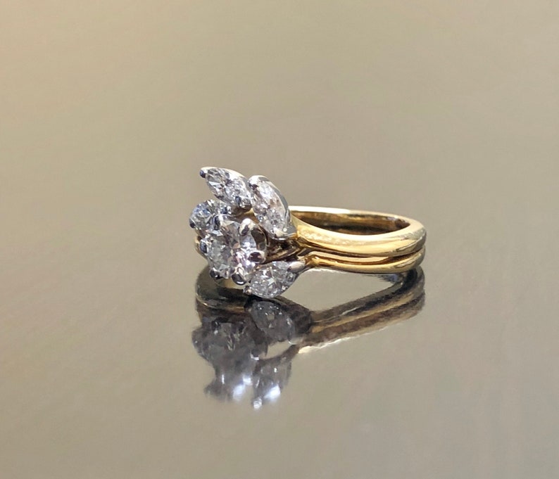 May include: A gold and white diamond engagement ring with a cluster of pear-shaped diamonds set in a delicate band.