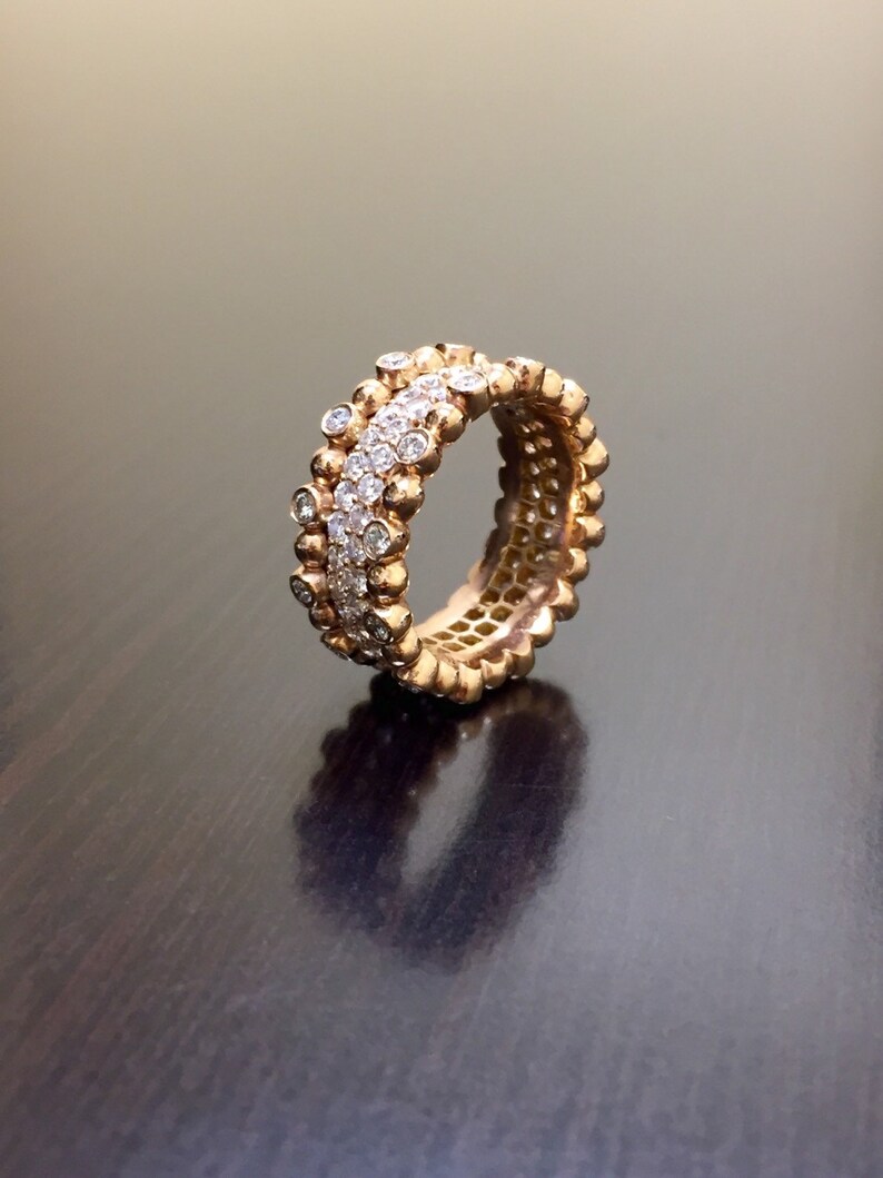 Pu&ograve; includere: Un anello d'oro con una fila di piccoli diamanti incastonati in una fascia di perline d'oro.