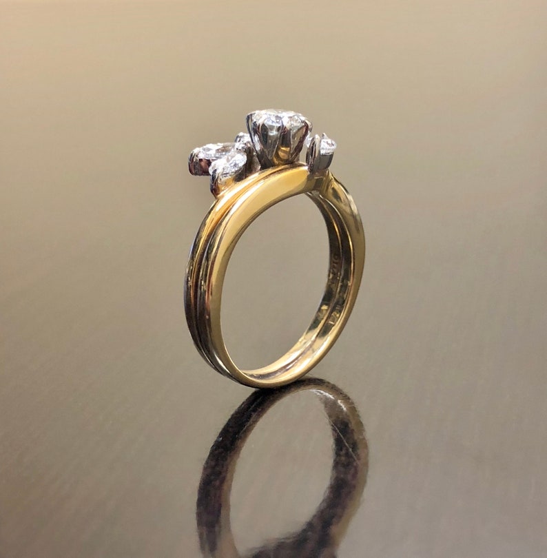 May include: A gold and silver wedding band set with a cluster of small diamonds. The band is set with a single larger diamond in the center.