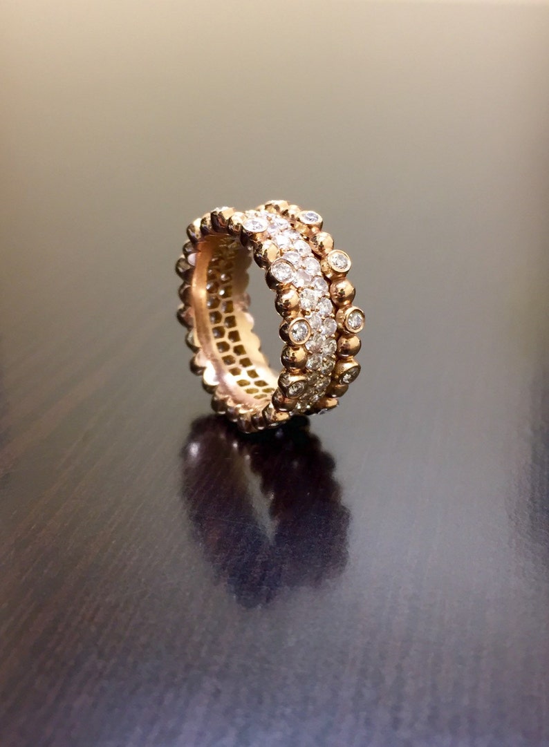 Pu&ograve; includere: Un anello a fascia d'oro con una doppia fila di piccoli diamanti rotondi. L'anello ha un design testurizzato.