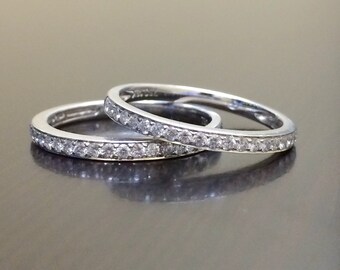 May include: Two silver wedding bands with a row of small diamonds set in the band.