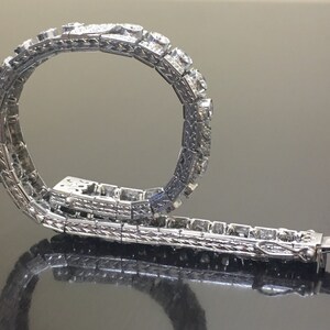 Puede incluir: Un brazalete de plata con un dise&ntilde;o delicado y una fila de diamantes brillantes.