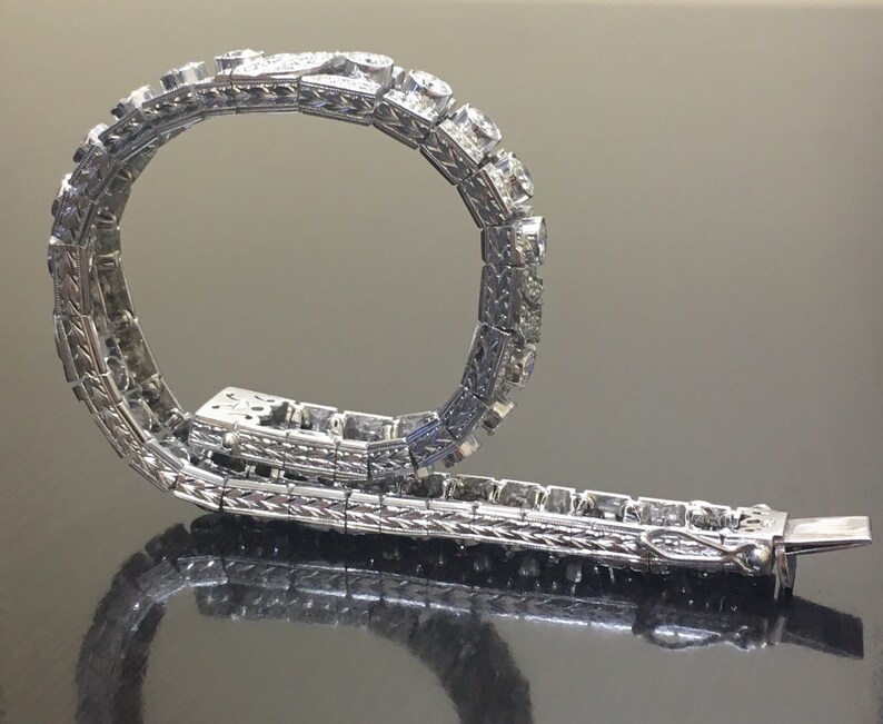 Puede incluir: Un brazalete de plata con un dise&ntilde;o delicado y una fila de diamantes brillantes.