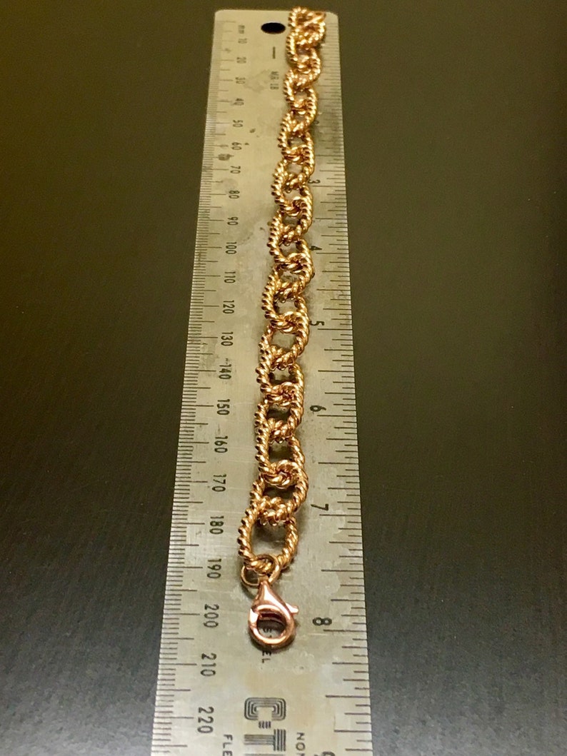 Puede incluir: Un brazalete de cadena dorado con cierre de langosta. El brazalete mide aproximadamente 20 cm de largo.