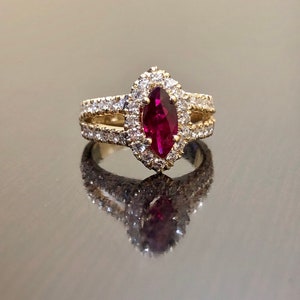 May include: A gold ring with a marquise-shaped ruby surrounded by a halo of smaller diamonds.
