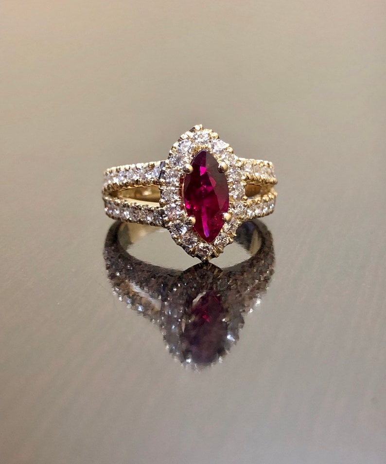 May include: A gold ring with a marquise-shaped ruby surrounded by a halo of smaller diamonds.