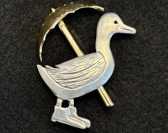 Broche vintage de pato con paraguas de peltre y tono dorado de la marca "Ultra Craft"