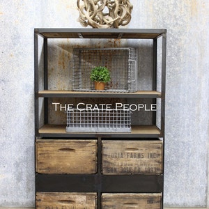 May include: A black metal shelving unit with wooden shelves and drawers. The shelves are decorated with wire baskets and a small potted plant. The drawers are made of wood and have labels that say "Zoria Farms Inc." and "San Jose CA 1993".