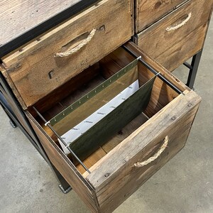 May include: A wooden file cabinet with five drawers. The drawers have rope handles and are made of reclaimed wood. The bottom drawer is open and shows a hanging file folder.