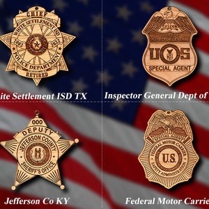 May include: Four wooden ornaments shaped like badges with different designs. The top left ornament is a star-shaped badge with the text "White Settlement ISD" and "Police Department Retired". The top right ornament is a shield-shaped badge with the text "Office of Inspector General" and "US Special Agent". The bottom left ornament is a star-shaped badge with the text "Deputy Jefferson County Sheriff's Office". The bottom right ornament is a shield-shaped badge with the text "Special Agent Federal Motor Carrier Safety Administration".