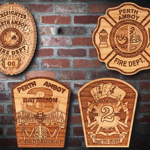 May include: Four wooden plaques with different designs, all featuring the words "Perth Amboy Fire Dept." The first plaque is a badge with a fire helmet and the words "Firefighter" and "Fire Dept." The second plaque is a six-pointed star with a fire hydrant, a ladder, and a ship. The third plaque is a shield with a skeleton holding axes and the words "Battalion 3." The fourth plaque is a shield with a fire axe, a ladder, and the words "Battalion 2" and "2nd to None."