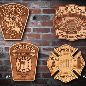 Könnte beinhalten: Vier Holzplaketten mit verschiedenen Feuerwehrlogos. Die obere linke Plakette ist für die Feuerwehr Lawrence Cedarhurst, die obere rechte Plakette ist für die Feuerwehr Atlantic Beach, die untere linke Plakette ist für die Feuerwehr Inwood und die untere rechte Plakette ist für die Feuerwehr Inwood mit der Nummer 316.