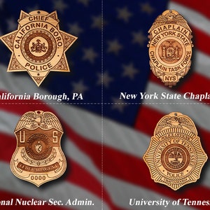 May include: Four wooden badges with different designs and text. The badges are in the shape of a star, a circle, and two shields. The text on the badges includes "Chief California Boro Police", "Chaplain New York State Chaplain Task Force NYS", "U.S. Federal Agent 0000", and "University of Tennessee Police Office Chattanooga".