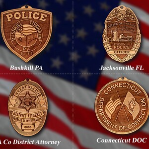 May include: Four wooden badges with different designs. The top left badge is a brown shield with the words "Police" and "Bushkill Township PA Est. 1813". The top right badge is a brown oval with the words "Office of Sheriff Jacksonville Police Officer". The bottom left badge is a brown oval with the words "Investigator District Attorney Bureau of Investigation 0000". The bottom right badge is a brown circle with the words "Connecticut Department of Correction".