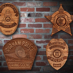 May include: Five wooden police badges with different designs and text. The badges are mounted on a brick wall. The badges feature the text "Riverside Police", "Durham Police", "Gurnee Police Department", "Officer Cranbury", and "Crime Scene".