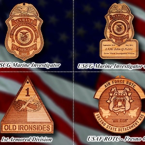 Könnte beinhalten: Vier Holzornamente mit verschiedenen Designs. Das Ornament oben links ist ein Abzeichen des US Coast Guard Marine Investigator. Das Ornament oben rechts ist ein Abzeichen des US Coast Guard Marine Investigator mit einem Namensschild. Das Ornament unten links ist ein Patch der 1. Panzerdivision. Das Ornament unten rechts ist ein Patch des USAF ROTC Fresno State Detachment 035.