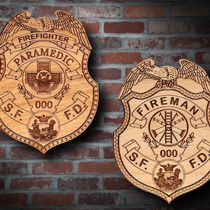 May include: Two wooden plaques with an eagle design and the words "Firefighter Paramedic" and "Fireman" on them. Both plaques have the words "S.F. 000 F.D."