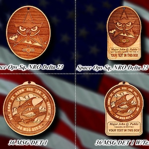 May include: Four wooden ornaments with different designs. The top left ornament features a stylized owl with a star and mountains. The top right ornament features the same owl design with the text "Space Ops Sq, NRO Delta 23" and "Major John Q. Public" with a space for personalized text. The bottom left ornament features a stylized airplane with the text "36 MSG DET 1". The bottom right ornament features the same airplane design with the text "36 MSG DET 1" and "Major John Q. Public" with a space for personalized text.
