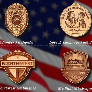 May include: Four wooden ornaments with different designs. The first ornament is a brown and gold badge with the text "ANY TEXT HERE VOLUNTEER FIREFIGHTER 000". The second ornament is a brown circle with the text "SPEECH LANGUAGE PATHOLOGIST SLP Jane Doe other text here if necessary". The third ornament is a brown shield with the text "CRITICAL CARE N*RTHWEST AMBULANCE TRANSPORT". The fourth ornament is a brown shield with the text "MedStat Emergency Medical Services A Global Medical Response Solution MISSISSIPPI ESTD 1996".