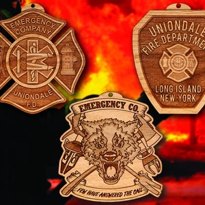 May include: Three wooden ornaments with a fire department theme. The first ornament is a red and white cross with the text "Emergency Company" and "Uniondale F.D.". The second ornament is a shield with the text "Uniondale Fire Department" and "Long Island New York". The third ornament features a wolf with crossed axes and the text "Emergency Co. Few Have Answered The Call."