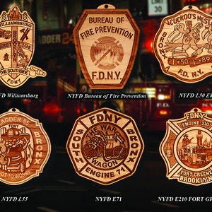 May include: Six wooden ornaments featuring the New York City Fire Department (FDNY) logo. Each ornament has a different design, including a fire engine, a ladder truck, and a firehouse. The ornaments are all made of wood and have a rustic, vintage look.