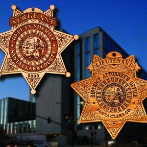 May include: Two wooden star-shaped badges with the text "Sergeant Deputy Sheriff Santa Clara County" and "Lieutenant District Attorney's Office Santa Clara Co."  The badges feature the seal of the State of California.