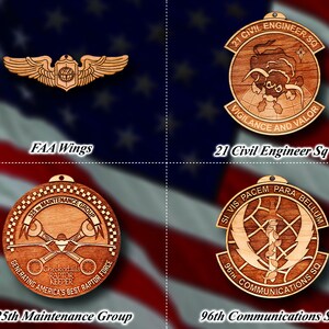 May include: Four wooden ornaments with different designs and text. The top left ornament is a pair of wings with a globe in the center. The top right ornament is a circle with a bull and the text "21 CIVIL ENGINEER SQ VIGILANCE AND VALOR". The bottom left ornament is a circle with a plane and the text "325TH MAINTENANCE GROUP GENERATING AMERICA'S BEST RAPTOR FORCE Checkertails RAPTOR KEEPER". The bottom right ornament is a circle with a sword and the text "SI VIS PACEM PARA BELLUM 96TH COMMUNICATIONS SQ".
