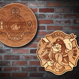 May include: Two wooden plaques with FDNY emblems. One is circular with text including "Engineering, Education, Enforcement" and a fire hydrant and other symbols. The other is a shield shape with a cartoon firefighter and the word "Rescue".