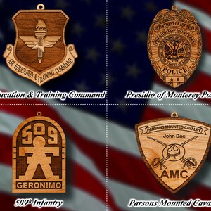May include: Four wooden ornaments featuring military insignia. The top left ornament features a brown and gold Air Education and Training Command logo. The top right ornament features a brown and gold Presidio of Monterey Police logo. The bottom left ornament features a brown and gold 509th Infantry logo. The bottom right ornament features a brown and gold Parsons Mounted Cavalry logo.