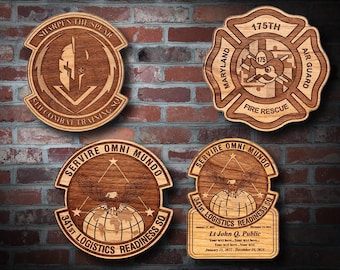 May include: Four wooden plaques with engraved designs. One features a spear and the text "SHARPEN THE SPEAR". Another is a fire rescue emblem with "175TH" and "MARYLAND AIR GUARD". The other two have an eagle and the text "SERVIRE OMNI MUNDO".