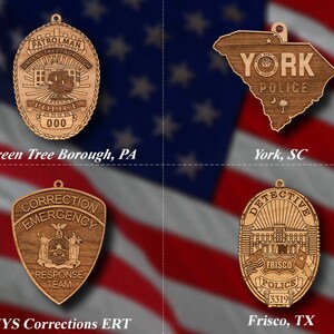 May include: Four wooden ornaments depicting police badges from different locations. The top left ornament reads "PATROLMAN GREEN TREE BOROUGH POLICE 000" and is labeled "Green Tree Borough, PA". The top right ornament is shaped like the state of South Carolina and reads "YORK POLICE" and is labeled "York, SC". The bottom left ornament reads "CORRECTION EMERGENCY RESPONSE TEAM" and is labeled "NYS Corrections ERT". The bottom right ornament reads "DETECTIVE FRISCO POLICE 3319" and is labeled "Frisco, TX".