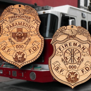 May include: Two wooden firefighter badges with an eagle design, the words "Firefighter Paramedic" and "Fireman" and the letters "S.F. F.D."