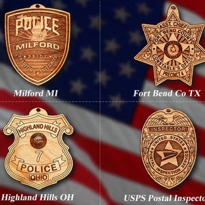 May include: Four wooden ornaments shaped like police badges. The top left badge is for the Milford Police Department in Michigan. The top right badge is for the Fort Bend County Constable's Office in Texas. The bottom left badge is for the Highland Hills Police Department in Ohio. The bottom right badge is for the United States Postal Inspection Service.