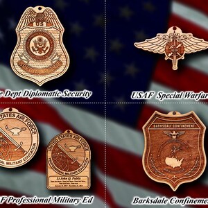 Könnte beinhalten: Vier Holzornamente mit verschiedenen Designs. Das Ornament oben links ist ein Schild mit dem Text "US SPECIAL AGENT" und einem Sternendesign. Das Ornament oben rechts ist eine geflügelte Figur mit dem Text "USAF SPECIAL WARFARE". Das Ornament unten links ist ein Kreis mit dem Text "UNITED STATES AIR FORCE PROFESSIONAL MILITARY EDUCATION". Das Ornament unten rechts ist ein Schild mit dem Text "BARKSDALE CONFINEMENT".
