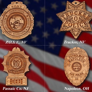 Könnte beinhalten: Vier Holzornamente in Form von Polizeibadgen. Das obere linke Abzeichen ist für die Peace Officers Standards and Training Commission in Nevada. Das obere rechte Abzeichen ist für die Polizei von Truckee in Nevada. Das untere linke Abzeichen ist für die Staatsanwaltschaft des Passaic County in New Jersey. Das untere rechte Abzeichen ist für die Hilfpolizei von Patrolman Napoleon in Ohio.