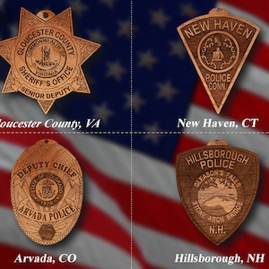 Könnte beinhalten: Vier hölzerne Polizeibadges mit unterschiedlichen Designs und Texten. Die Abzeichen stammen aus Gloucester County, VA, New Haven, CT, Arvada, CO und Hillsborough, NH.