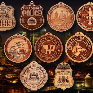 May include: A collection of wooden Philadelphia Police badges and medallions. The badges include the text "Police Department", "Police", "Detective", and "Chief Inspector". The medallions feature "Crime Scene Unit", "Aviation Unit", "Highway Patrol", and "K-9 Unit".
