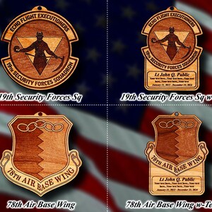 May include: Four wooden ornaments with different designs. The top left ornament is a circle with a person holding a weapon and the text "Echo Flight Executioners 19th Security Forces Squadron". The top right ornament is the same circle with the text "Lt John Q. Public Your text here. Your text here. Your text here. January 21, 2022 - December 23, 2024". The bottom left ornament is a shield with the text "78th Air Base Wing". The bottom right ornament is the same shield with the text "Lt John Q. Public Your text here. Your text here. Your text here. January 21, 2022 - December 23, 2024".