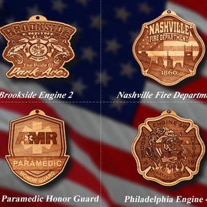 May include: Four wooden ornaments with different designs. The first ornament is a brown wooden shield with the text "Brookside Engine 2" and "The Pride of Park Ave." The second ornament is a brown wooden shield with the text "Nashville Fire Department" and "1860." The third ornament is a brown wooden shield with the text "AMR Paramedic Honour Guard." The fourth ornament is a brown wooden shield with the text "Engine 40" and "Junkyard Dogs."