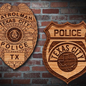 May include: Two wooden police badges, one with the text "PATROLMAN TEXAS CITY POLICE TX" and the other with the text "POLICE TEXAS CITY". Both badges feature a star and the outline of the state of Texas.