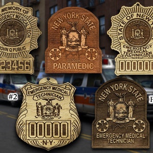 May include: Four wooden New York State Emergency Medical Technician badges. The badges are in the shape of a star, shield, and rectangle. The badges feature the New York State seal and the words "New York State" and "Emergency Medical Technician".
