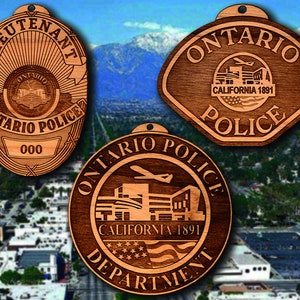 May include: Three wooden ornaments featuring the Ontario Police Department logo. The top ornament is a shield with the words "Lieutenant" and "Ontario Police" around the edge. The middle ornament is a shield with the words "Ontario Police" around the edge. The bottom ornament is a circle with the words "Ontario Police Department" around the edge.