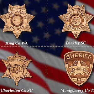 May include: Four wooden sheriff's badges with different county names and state abbreviations. The badges are in the shape of a star with a sheriff's star in the center. The badges are on a red, white, and blue background.