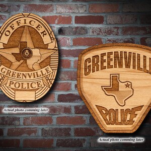 Könnte beinhalten: Zwei Holzplaketten mit Polizeimotto. Die erste Plakette ist ein Abzeichen mit den Worten "OFFICER" und "GREENVILLE POLICE" und einem Stern mit dem Bundesstaat Texas darin. Die zweite Plakette ist ein Schild mit den Worten "GREENVILLE POLICE" und dem Bundesstaat Texas darin.