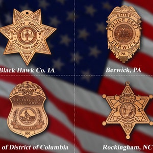 May include: Four wooden police badges with different designs and text. The badges are in the shape of a star, a shield, and a circle. The text on the badges includes the names of the police departments, the state, and the county. The badges are on a red, white, and blue background.