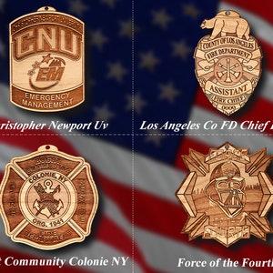 May include: Four wooden badges with intricate designs. The badges include a Christopher Newport University Emergency Management badge, a Los Angeles County Fire Department Chief badge, a Boght Community Colonie NY Fire Department badge, and a Force of the Fourth badge.