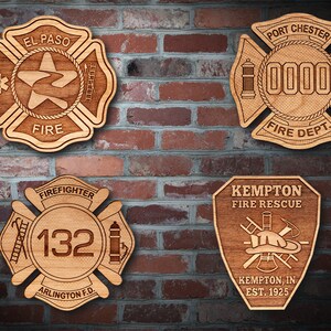 May include: Four wooden firefighter badges with different designs. The top left badge is for El Paso Fire, the top right badge is for Port Chester Fire Department, the bottom left badge is for Arlington Fire Department, and the bottom right badge is for Kempton Fire Rescue.