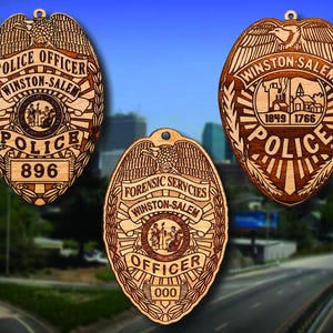 May include: Three wooden police badges with the text "Winston-Salem Police" and different department designations. The badges are brown with gold accents and feature a stylized eagle design.