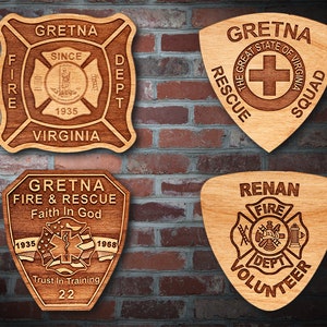 Könnte beinhalten: Vier Holzplaketten mit verschiedenen Feuerwehrlogos. Die obere linke Plakette ist ein braunes und beigefarbenes Quadrat mit dem Text "Gretna Fire Dept. Since 1935 Virginia". Die obere rechte Plakette ist ein braunes und beigefarbenes Schild mit dem Text "Gretna Rescue Squad The Great State of Virginia". Die untere linke Plakette ist ein braunes und beigefarbenes Schild mit dem Text "Gretna Fire & Rescue Faith In God 1935 1968 Trust In Training 22". Die untere rechte Plakette ist ein braunes und beigefarbenes Schild mit dem Text "Renan Fire Dept. Volunteer".