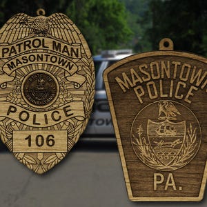 May include: Two wooden police badges, one with a traditional shield shape and the text "PATROL MAN MASONTOWN POLICE 106", and the other with a more modern shape and the text "MASONTOWN POLICE PA."